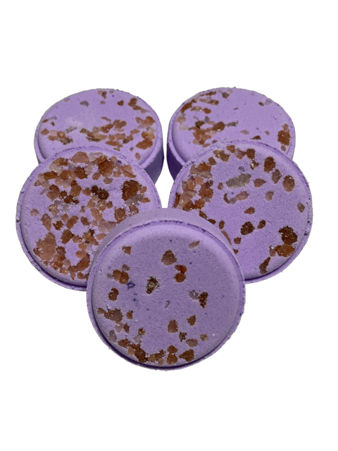Round purple shower steamers with brown speckles, designed to be used in the shower.
