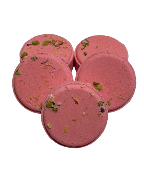 Round pink shower steamers with visible green chamomile petals embedded in them.