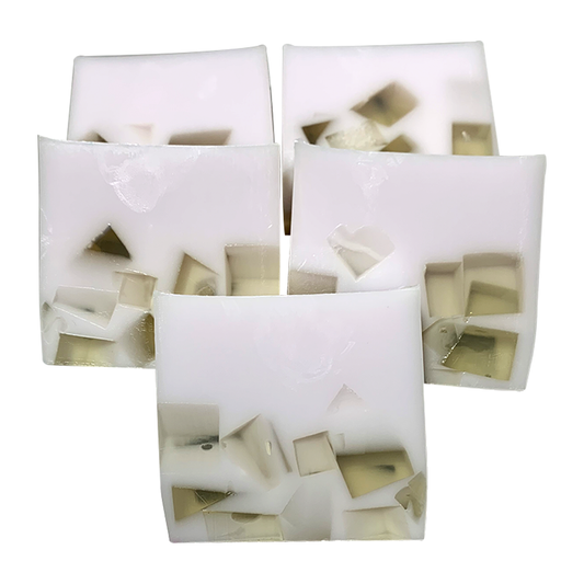 Handmade soap bars with visible green flecks, packaged in clear wrapping.